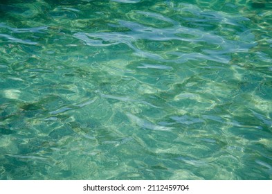 Aerial View Of Aquamarine Sea Surface. Rough Sea Texture. Top View Natural Background Of Rippled Sea-green Sea Water. Marine Theme With Copy Space.