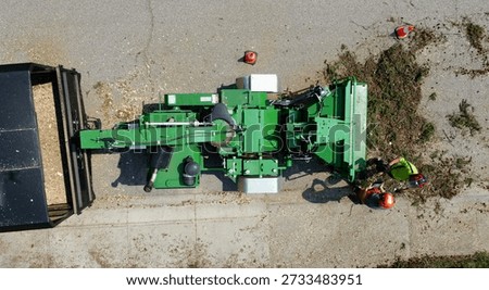 Aerial view of arborists loading branches into a wood chipper