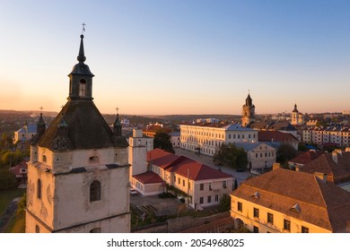 Aerial view of the Armenian Cathedral with wooden roof tiles and four small turrets and city panorama background in evening time in Kamyanets-Podilsky, Ukraine