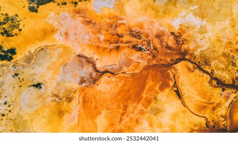 Aerial view of an artistic, swirling blend of earthy ochre, burnt orange, and pale gold hues with hints of green and soft textures resembling a rugged landscape. - Powered by Shutterstock