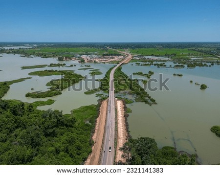 Aerial view of asphalt roads and green forests in lower Moon River basin, Thailand. Abundance of lowland forest rash and roads through jungle. Tropical Forest Ecosystem and Mun River Basin in Thailand