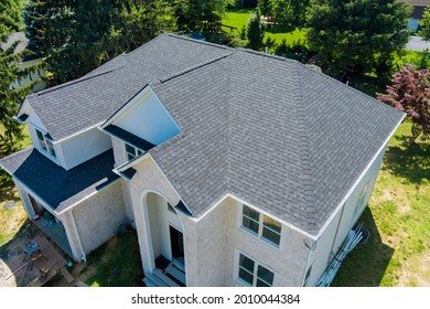 Aerial view of asphalt shingles construction site roofing the house with new window - Shutterstock ID 2010044384