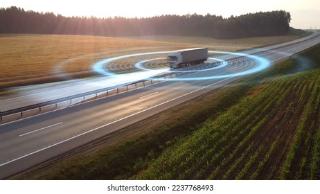 Aerial view of autonomous truck driving on autopilot on a highway with traffic sensors scanning surroundings. Cargo delivery, transportation of the future. Artificial intelligence. Self driving.