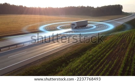Aerial view of autonomous truck driving on autopilot on a highway with traffic sensors scanning surroundings. Cargo delivery, transportation of the future. Artificial intelligence. Self driving.