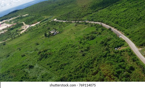 Aerial View Of The Backroad Near The Saipan International Airport, With A Few Buildings In The Farms