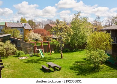 Aerial view of a backyard in a small city (village). Barbecue area, camping site, playground slide and swing. Spring landscape. Idyllic rural scene. Architecture, vacations, downshifting, lifestyle - Powered by Shutterstock