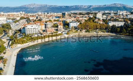 Aerial view of Bacvice Beach in Split, Croatia, showcasing the clear blue waters, sandy shoreline, and vibrant atmosphere of this popular tourist destination along the Dalmatian coast