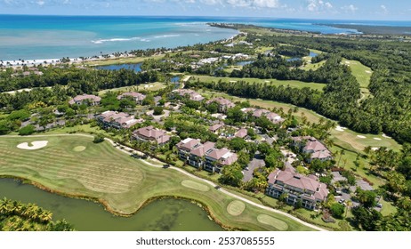 Aerial view of Bahia Beach golf course resort in Rio Grande, PR. Showcasing vibrant green fairways, palm-lined paths, scenic vistas, and ocean views in the distance, all under a clear blue sky.  - Powered by Shutterstock