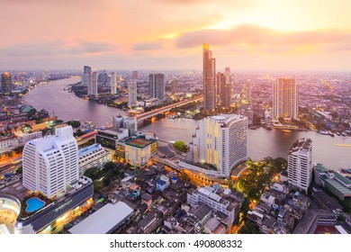 Aerial view of Bangkok modern office buildings, condominium in Bangkok city downtown with Chao Phraya river during sunset sky , Bangkok , Thailand