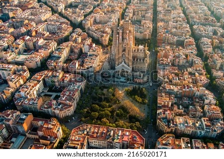 Aerial view of Barcelona Eixample residential district and Sagrada Familia Basilica at sunrise. Catalonia, Spain. Cityscape with typical urban octagon blocks