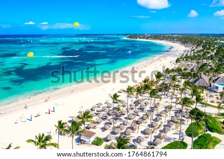 Aerial view of Bavaro beach Punta Cana tropical resort in Dominican Republic. Beautiful atlantic tropical beach with palms, umbrellas and parasailing balloons