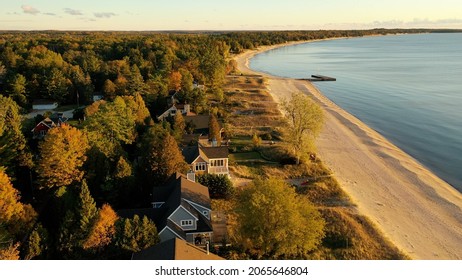 Aerial View Of Beachfront Houses. Establishing Shot Of Waterfront Homes. Sunset Sunrise Sunlight,  Fall Autumn Colorful Trees. Midwest USA, Door County Wisconsin, Lake Michigan.