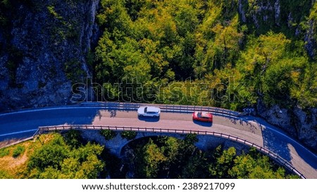 Aerial view of a beautiful asphalt road and bridge along Lake Como. Cars and motorcycles on the road. Pure water. Rocks over water. Ponte del Diavolo. Travel to Europe. Drone photography. Green Planet