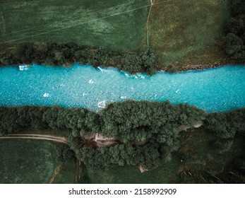 An Aerial View Of A Beautiful Blue River In The Middle Of Green Landscape