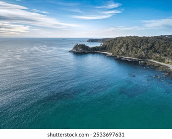 Aerial view of a beautiful coastal landscape with clear blue waters and lush green forest, showcasing a serene and picturesque scenery. - Powered by Shutterstock