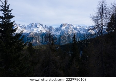 Aerial view of beautiful Dolomites mountains in Italy. Madona di Campiglio in Trentino South Tyrol regon. Autumn season in Dolomites Mountains. Mountain forest. Mountains peaks covered with snow. 