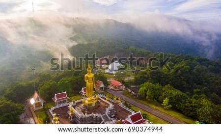 Aerial view beautiful fog and buddha statue in sunrise
