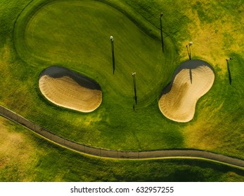 Aerial view of a beautiful golf course with players. Putting green with bunkers.