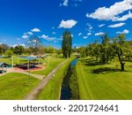 An aerial view of a beautiful green park with a narrow river in Armidale, Australia