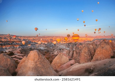 Aerial view of beautiful hot air balloons at sunrise over Cappadocia unique landscape.
