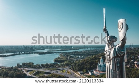 Aerial view to the  Beautiful landscape city Kiev with a Dnepr river. Top view to the Motherland statue in the Kiev. The well-known landmarks in Kyiv. Historical monument of Soviet union. 
