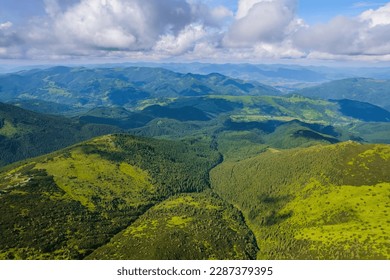 Aerial view of beautiful mountain forest covered with fluffy clouds. Drone photography - Powered by Shutterstock