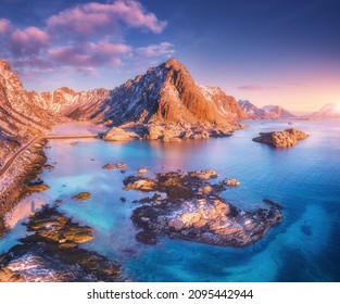 Aerial view of beautiful mountains, small islands in the sea, road, blue sky at sunset in Lofoten islands, Norway in winter. Top view of road, snowy rocks, stones, sea coast, clear water. Top view - Powered by Shutterstock