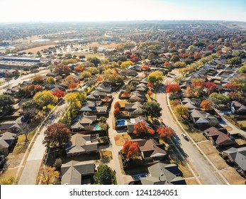 Aerial view beautiful neighborhood in Coppell, Texas, USA in autumn season. Row of single-family home with attached garage, garden, swimming pool surrounded by colorful fall foliage leaves