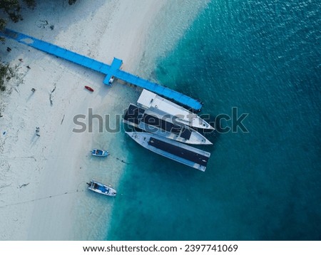 Aerial view of the beautiful Peucang Island Pier Harbor within the Ujung Kulon National Park at Banten. Landscape of the blue ocean with beautiful white sand beaches on the edge of the island.