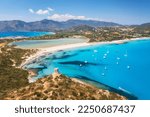 Aerial view of beautiful sandy beach, old tower on the hill, sea bays, mountains at summer sunny day. Porto Giunco in Sardinia, Italy. Top view of blue sea with clear water, white sand, mountains
