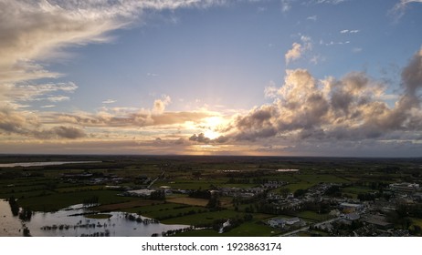 Aerial View Of Beautiful Sunset Over Rural Village In Ireland, Sun Emerging From Clouds