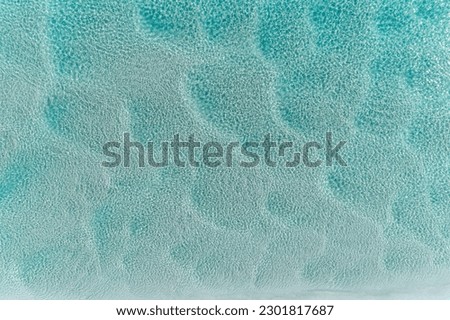 Aerial view of beautiful tropical turquoise ocean sea waters with shallow waves. Vibrant bright sunny day in summer wallpaper. Seascape background. Coastal wallpaper.