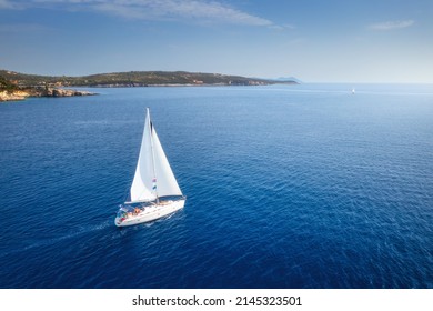 Aerial view of beautiful yacht. Boat on the sea at sunset in summer. Lefkada island, Greece. Top view of luxury yachts, sailboats, clear blue water, sky, mountain. Travel. Cruise vacation. Yachting - Powered by Shutterstock