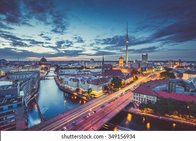 Aerial view of Berlin skyline with dramatic clouds in twilight during blue hour at dusk with retro vintage old Instagram style filter effect, Germany