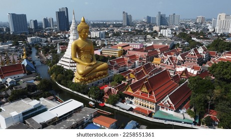 Aerial view of a big Buddha golden statue at Wat Paknam Phasi Charoen temple in Bangkok, Thailand. The statue, made of bronze and gold, measures 96 meters tall and 40 meters wide. - Shutterstock ID 2258551361
