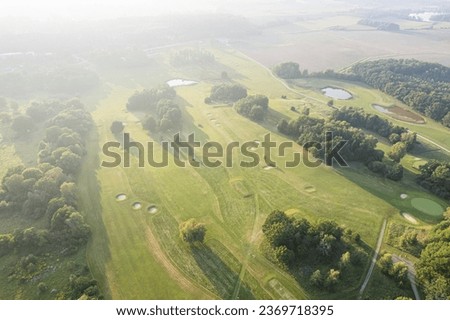 Similar – A tranquil aerial view of a lush golf course fairway, bathed in the warm glow of sunset. Ideal for themes of relaxation, nature, and sports, this image captures the peaceful beauty of the golfing experience.