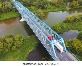 Aerial View Of A Blue Bridge Over A Lazy River In Green Scenery