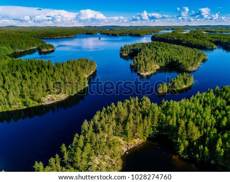 Aerial view of blue lakes and green forests on a sunny summer day in Finland. drone photography