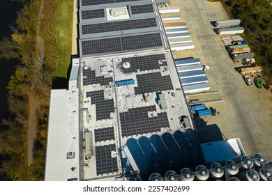 Aerial view of blue photovoltaic solar panels mounted on industrial building roof for producing green ecological electricity. Production of sustainable energy concept - Shutterstock ID 2257402699