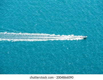 Aerial view of blue sea and motor boat with wavy splash track on water surface - Powered by Shutterstock