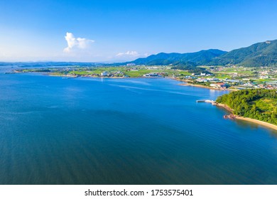 Aerial view of the blue sea with a village near Sacheon-si, South Korea