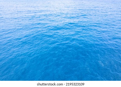 Aerial View Of A Blue Sea Water Background And Sun Reflections. Aerial Flying Drone View And Shadow Clouds On Sea Surface,water Texture On Ocean, Aerial Photography. Birds Eye View. Sea