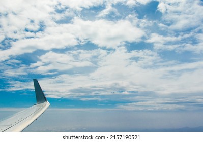 Aerial view of blue sky with clouds from the plane window.