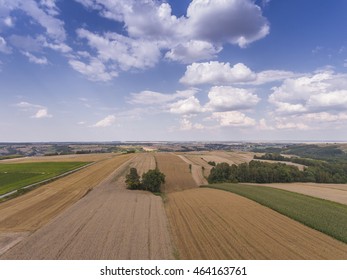 Aerial view of the blue sky and village harvest fields at summer time in Poland