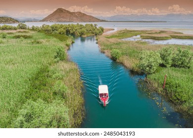 Aerial view of a boat tour on Lake Skadar, Montenegro, showcasing the scenic summer landscape and calm waters. - Powered by Shutterstock