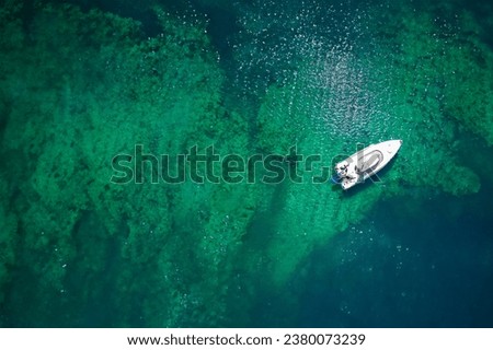 Aerial view of a boat in turquoise water. Top view