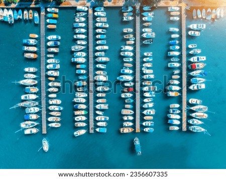 Aerial view of boats and luxure yachts in dock at sunset in summer in Krk island, Croatia. Colorful landscape with sailboats and motorboats in sea bay, jatty, clear blue sea. Top view of harbor