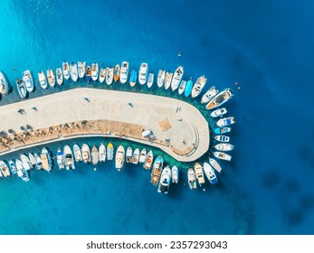 Aerial view of boats and luxury yachts in dock at sunset in summer in Krk island, Croatia. Colorful landscape with sailboats and motorboats in sea bay, jetty, clear blue sea. Top view of harbor - Powered by Shutterstock