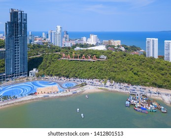 Aerial view of boats in Pattaya sea, beach, and urban city with blue sky for travel background. Chonburi, Thailand.
