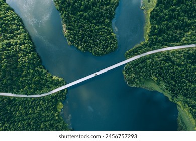 Aerial view of bridge asphalt road with cars and blue water lake and green woods in Finland. - Powered by Shutterstock